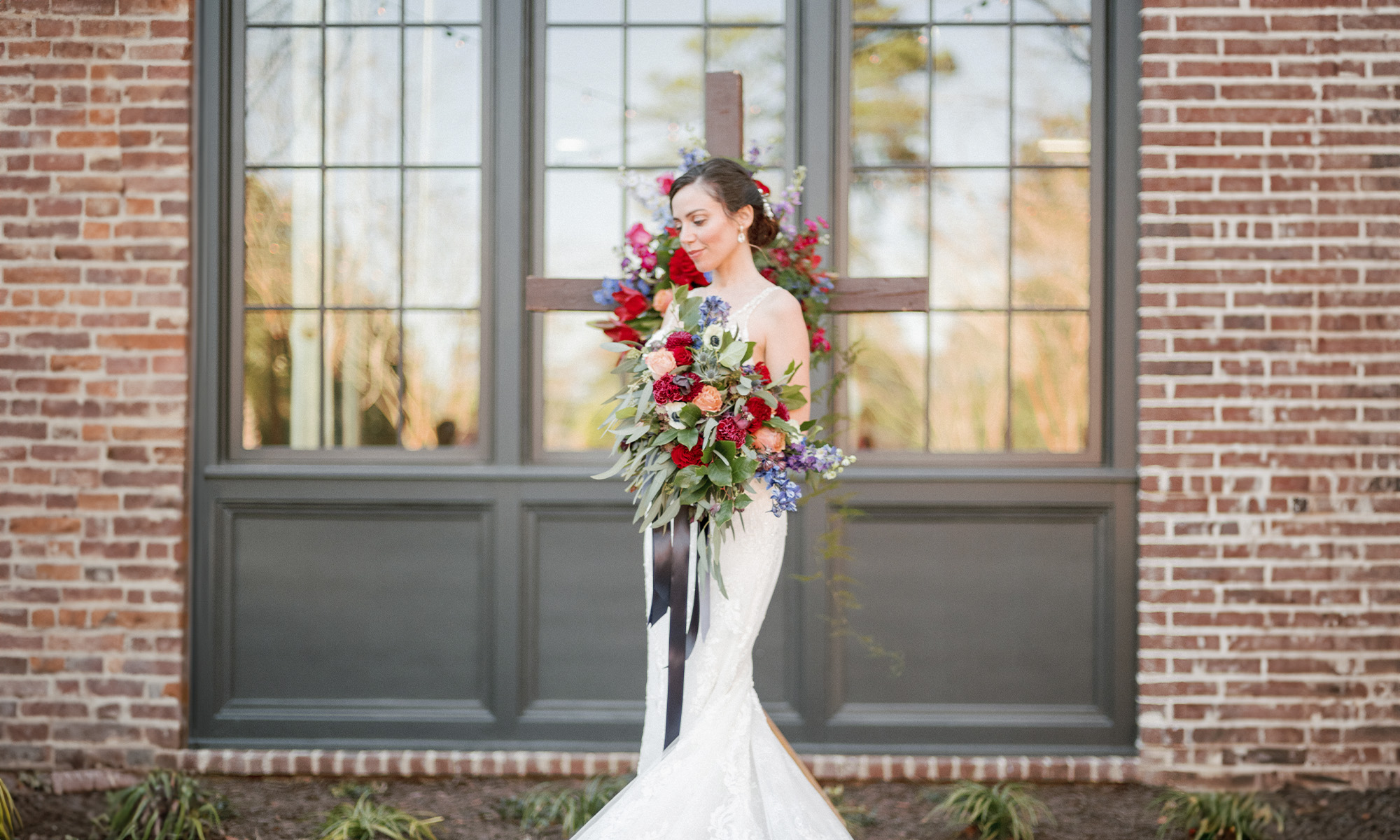 Blush Bridal and Formal Wear - bride in front of Burnt Church Distillery